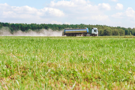 A tanker truck travels at speed through fieldsの写真素材