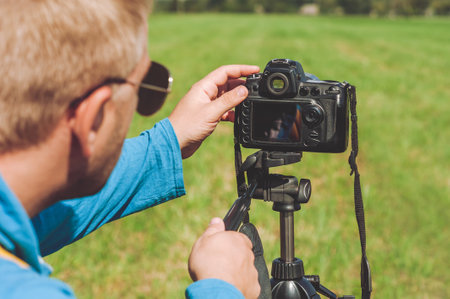 Professional Photographer takes pictures on the background of the landscapeの写真素材