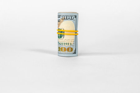 Close-up of a roll of money. On a light background