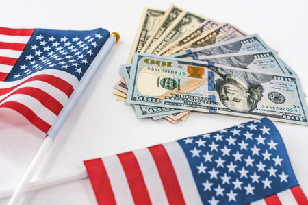Money dollar bills with the American flag on a white backgroundの写真素材