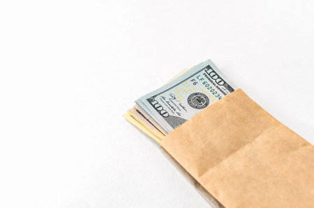 Money us dollars in a paper bag on a white backgroundの写真素材