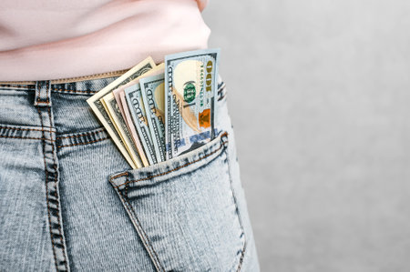 Close-up. American dollars in the back pocket of the girl's jeans. On a light backgroundの写真素材