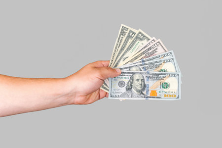 American money in the guy's hand on a white-gray background