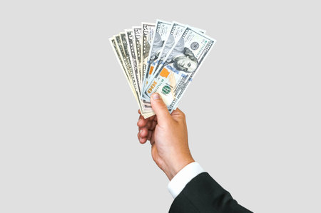 Close-up, American dollars money in the hand of a business man. White and gray backgroundの写真素材