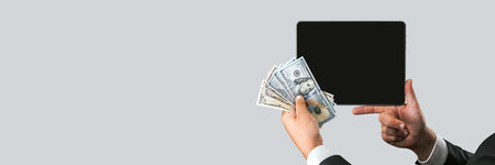 Banner, A man in a business suit holds a tablet mockup with money on a gray and white background