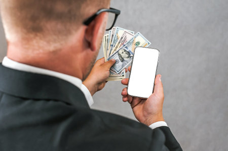 Smartphone mockup with American dollars in the hands of a businessman. on a light gray background