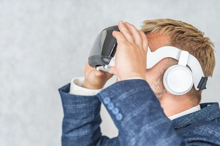 Portrait of a serious business man with virtual reality glasses on his head. On a light background