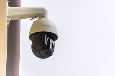 A white and black CCTV dome camera is mounted outdoors, ideal for modern security and surveillance...