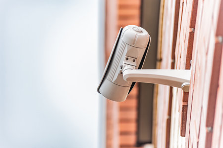 A wall-mounted security camera is attached to a exterior brick, ensuring surveillance. The sleek...