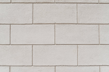 Close-up of a wall made of rectangular white concrete blocks, showing a textured, geometric pattern.