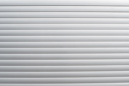 A modern gray garage door with a slatted design, perfect for contemporary homes. The sleek finish enhances residential exteriors with a minimalist look.の写真素材