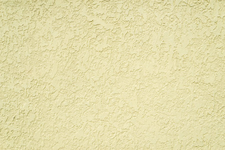 A textured cream wall background, perfect for design and decor projects. The rough surface adds depth and character to any creative backdrop.の写真素材