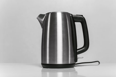 A sleek stainless steel electric kettle with a black handle, isolated on a white background. Perfect for kitchen, appliance, and modern home decor concepts.の写真素材