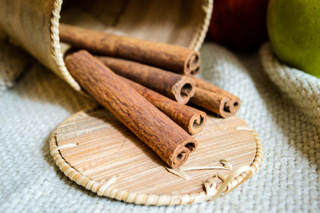 Spices cinnamon sticks on the cloth on a wooden table