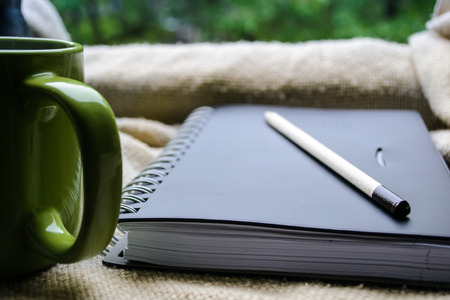 cup of coffee and a book on a windowの写真素材