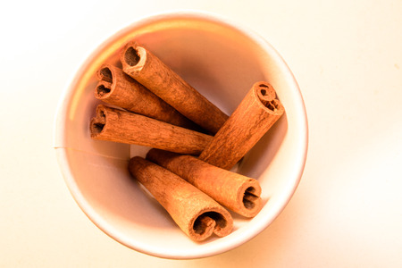 cinnamon stick and spices on a white table in a glassの写真素材