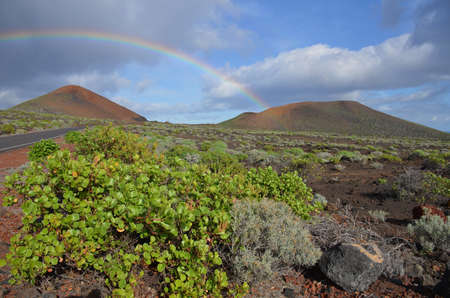 Landscapes of the volcanoes of the iron island in the Canary Islands, Spain, with rainbowの写真素材