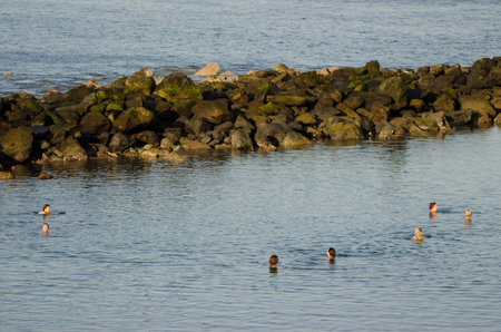 Playa de Arinaga, March 30, 2021: People bathing in the sea. Aguimes. Gran Canaria. Canary Islands. Spain.のeditorial素材