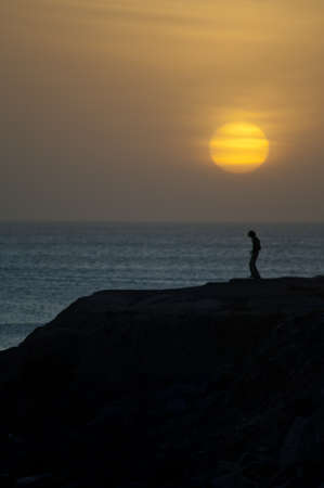 Man dancing at sunset in the coast of Dakar. Senegal.