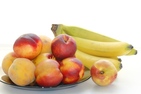 beautiful, delicious peaches, bananas on a light backgroundの写真素材
