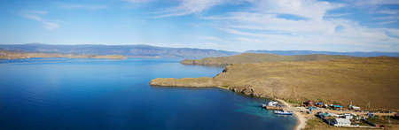 Lake Baikal on a sunny summer day. Panorama of the Olkhon Gate Strait. A ferry carries passengers to...