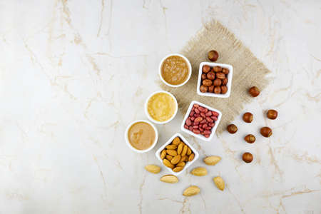 Nuts butter in bowls with ingredients. Homemade raw organic peanut, hazelnut, almond paste or butter. Copy space. Top view.の写真素材