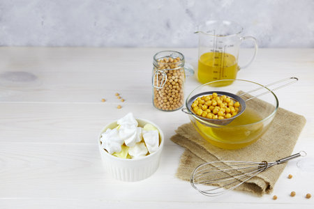 Vegan meringue from aquafaba on a white wooden background. Chickpea brine, boiled chickpea. Replace egg for vegan recipe.の写真素材