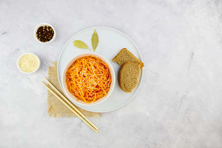 Spicy pickled carrots in a bowl on a gray background, spicy Korean appetizer. Vegan healthy food.の写真素材