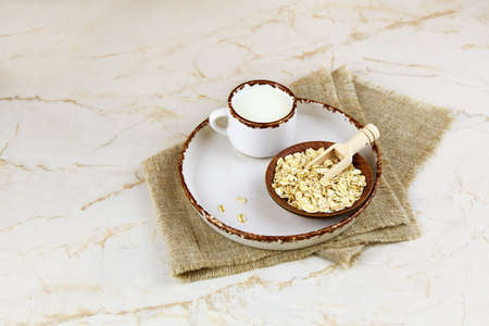A cup of oat milk and oatmeal in a ceramic bowl. Vegetable milk. Vegan lactose free.の写真素材