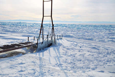 Icy pier, a device for launching a boat into the lake. Frozen Lake Baikal, hummocks.の写真素材