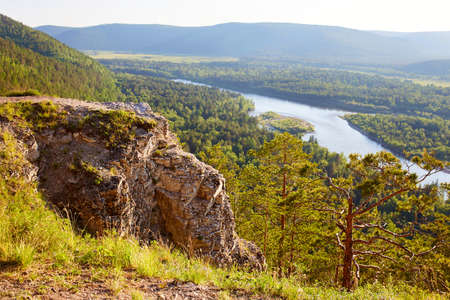 Beautiful view from the cliff to the rocks, river, forest on a summer day.の写真素材