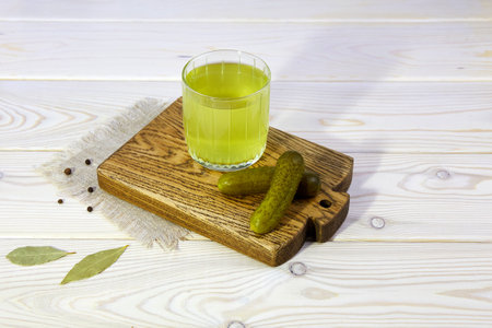Pickle juice or cucumber pickle on a wooden background. Healthy energy drink for athletes. Top view.の写真素材