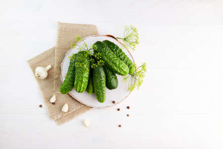 Fresh cucumbers with dill and garlic on a wooden background. Ingredients for pickling cucumbers.の写真素材