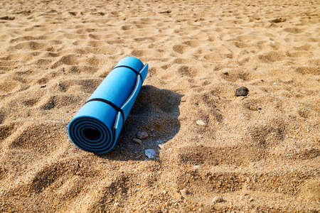 Blue mat for yoga, for fitness, for tourism on a sandy beach.の写真素材