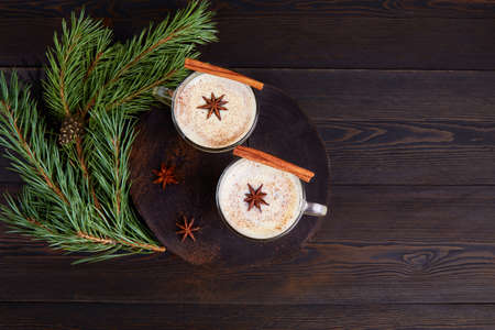 Traditional winter eggnog on dark wooden background.