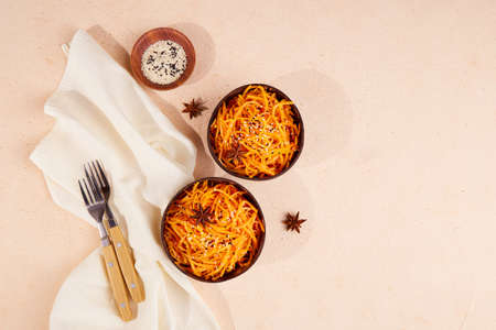 Fresh organic grated carrot with pepper, sesame and garlic. Korean carrot salad in coconut bowls. Vegan healthy food.の写真素材
