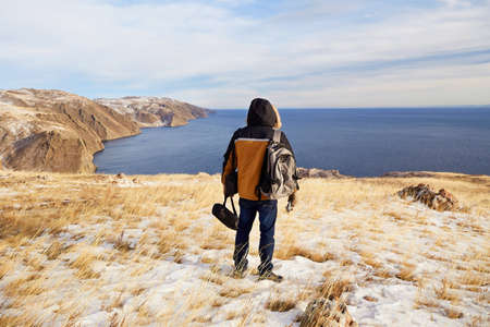 Man enjoys hiking in nature. Trips to Lake Baikal in winter. Adventure, healthy lifestyle, outdoor activities.の写真素材