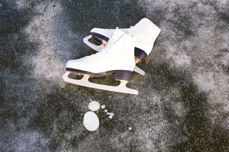 White womens skates for figure skating on the ice of the lake. Natural background, ice of Lake...
