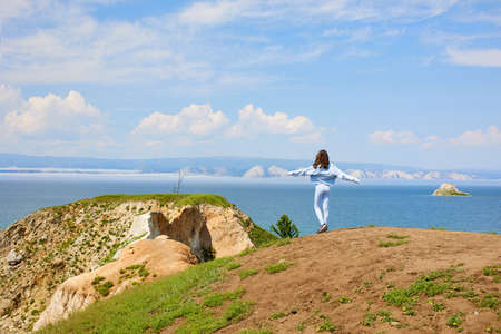 A young girl travels on Lake Baikal in the summer. Beautiful landscape of Olkhon Island.