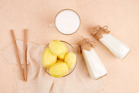 Vegan potato milk in bottles and mug. A plant based milk substitute. The concept is lactose free, dairy free. top view.の写真素材