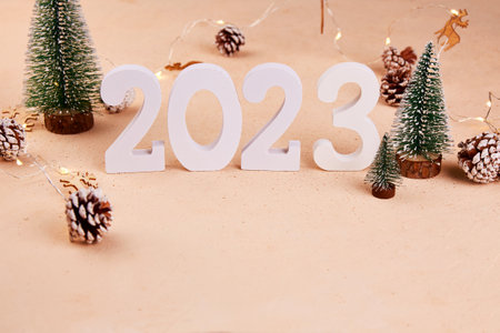 Happy New Year 2023 and Merry Christmas greeting card. Decorative Christmas trees, a garland of pine...