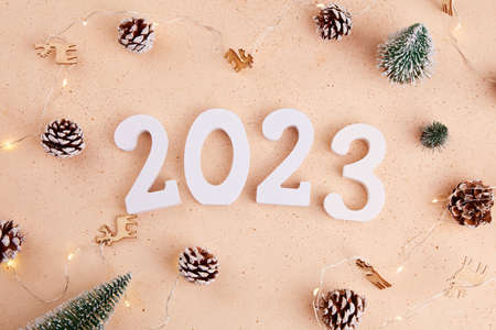Happy New Year 2023 and Merry Christmas greeting card. Decorative Christmas trees, a garland of pine...