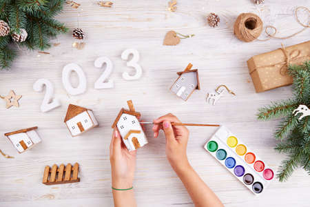 The girls hands paint homemade wooden houses