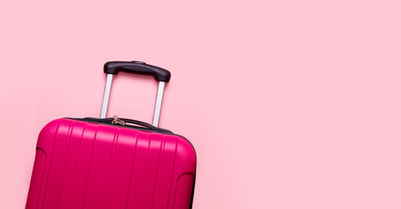 Suitcase on a pink background. Banner. The concept of travel, vacation, luggage packing. copy spaceの写真素材