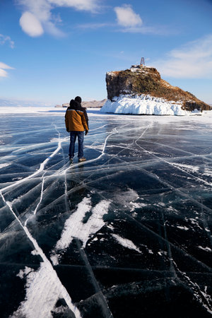 A man stands on the transparent ice with cracksの写真素材
