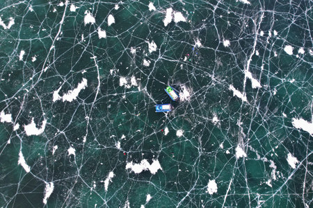 Aerial view on the ice pattern of Lake Baikal with cracks. A hovercraft transports tourists across the ice. winter travel. aerial view.の写真素材
