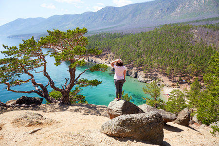 A female traveler enjoys a beautiful view of the lakeの写真素材