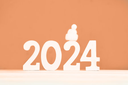 Wooden numbers 2024 and on a peach background. Festive background. Peach Fuzz Color of Year 2024.の写真素材