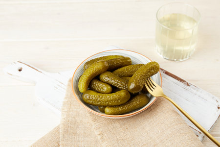Homemade pickles. Marinated gherkins in a bowl and pickled juice or cucumber pickle.の写真素材