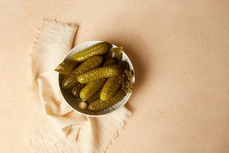 Marinated gherkins in a bowl on a light background. Homemade pickles. Close-up. Top view.の写真素材